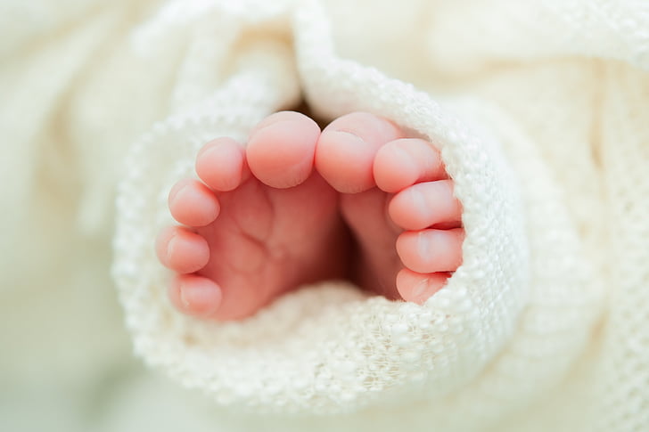 baby feet wrapped in white knit blanket donate or go to our how to help page for charity